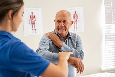 Female Doctor with Senior at Electrotherapy for Pain Relief Stock